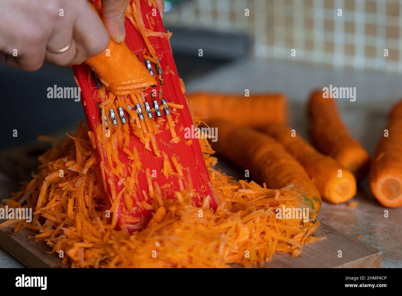 hostess's hands grate carrots on a grater for Korean carrots, lifestyle