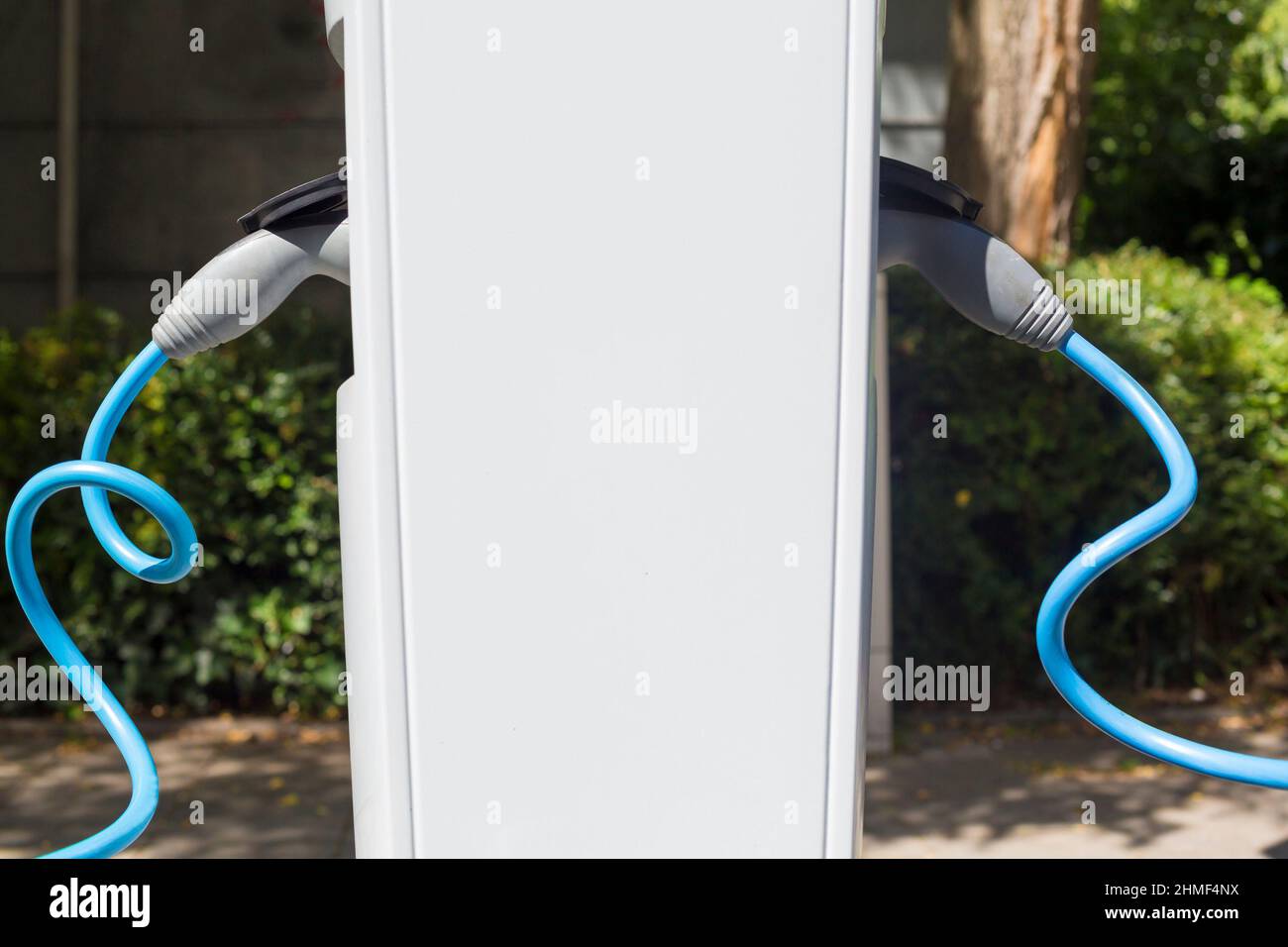 Power supply for electric car charging. Electric car charging station. Close up of the power supply plugged into an electric car being charged. Stock Photo