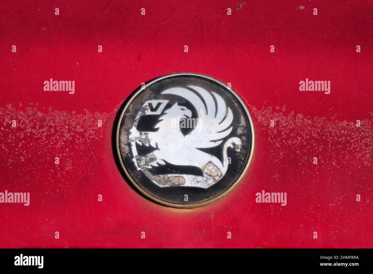 Vauxhall car logo on red paint, Vauxhall emblem on red car sheet metal