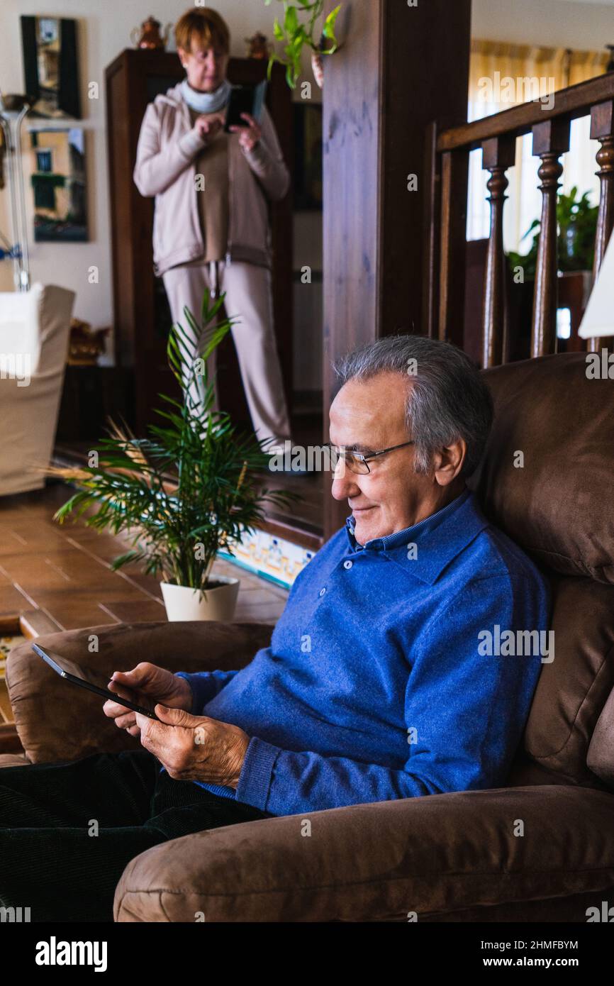Old man looking at tablet in sofa Stock Photo