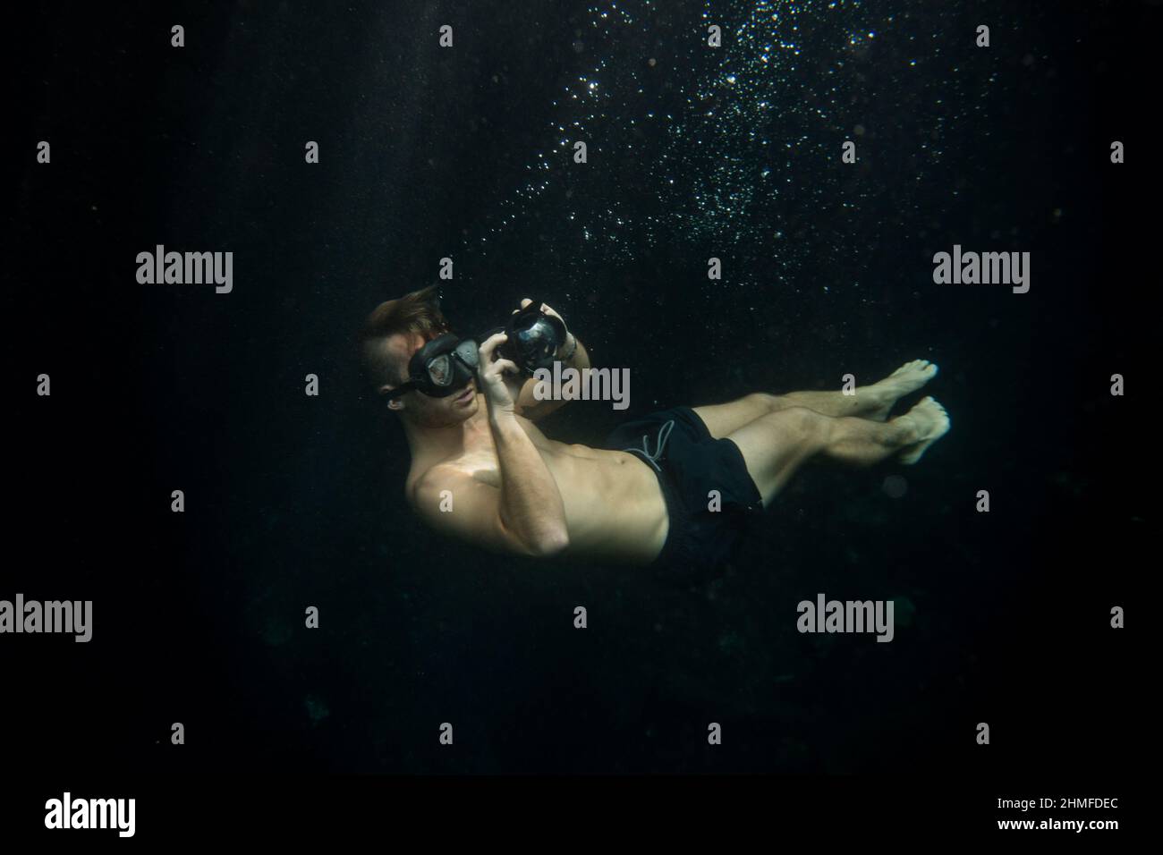 young man taking underwater pictures doing free dive Stock Photo