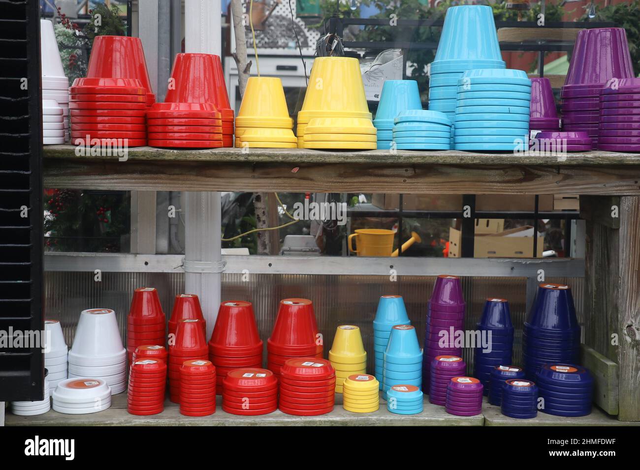 colorful plastic plant pots and drain plates on shelfs at a garden