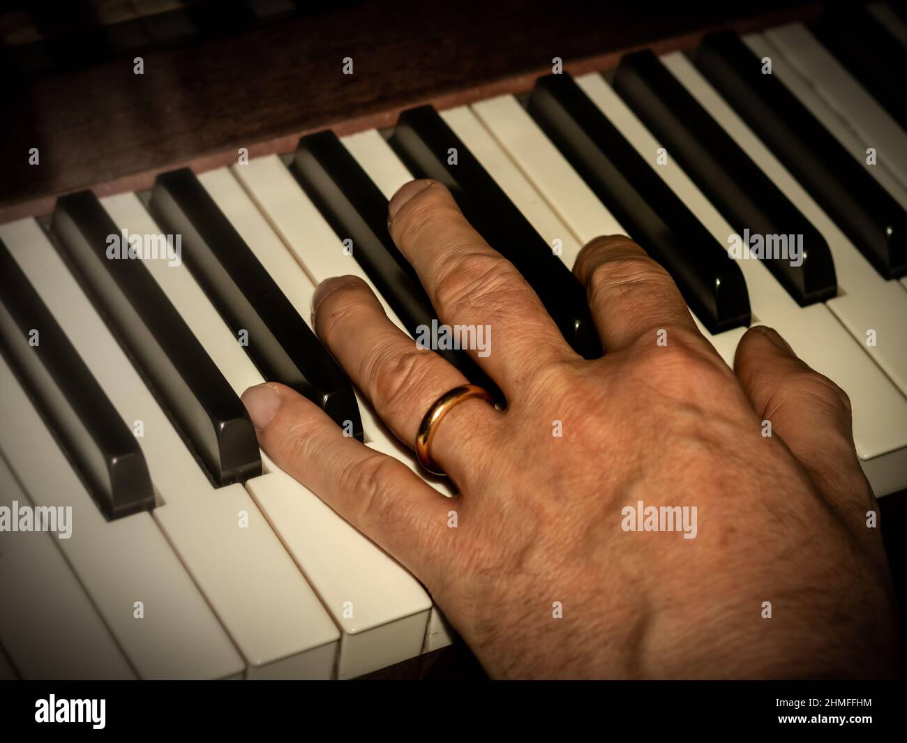 closeup of a man's hand on a piano keyboard Stock Photo