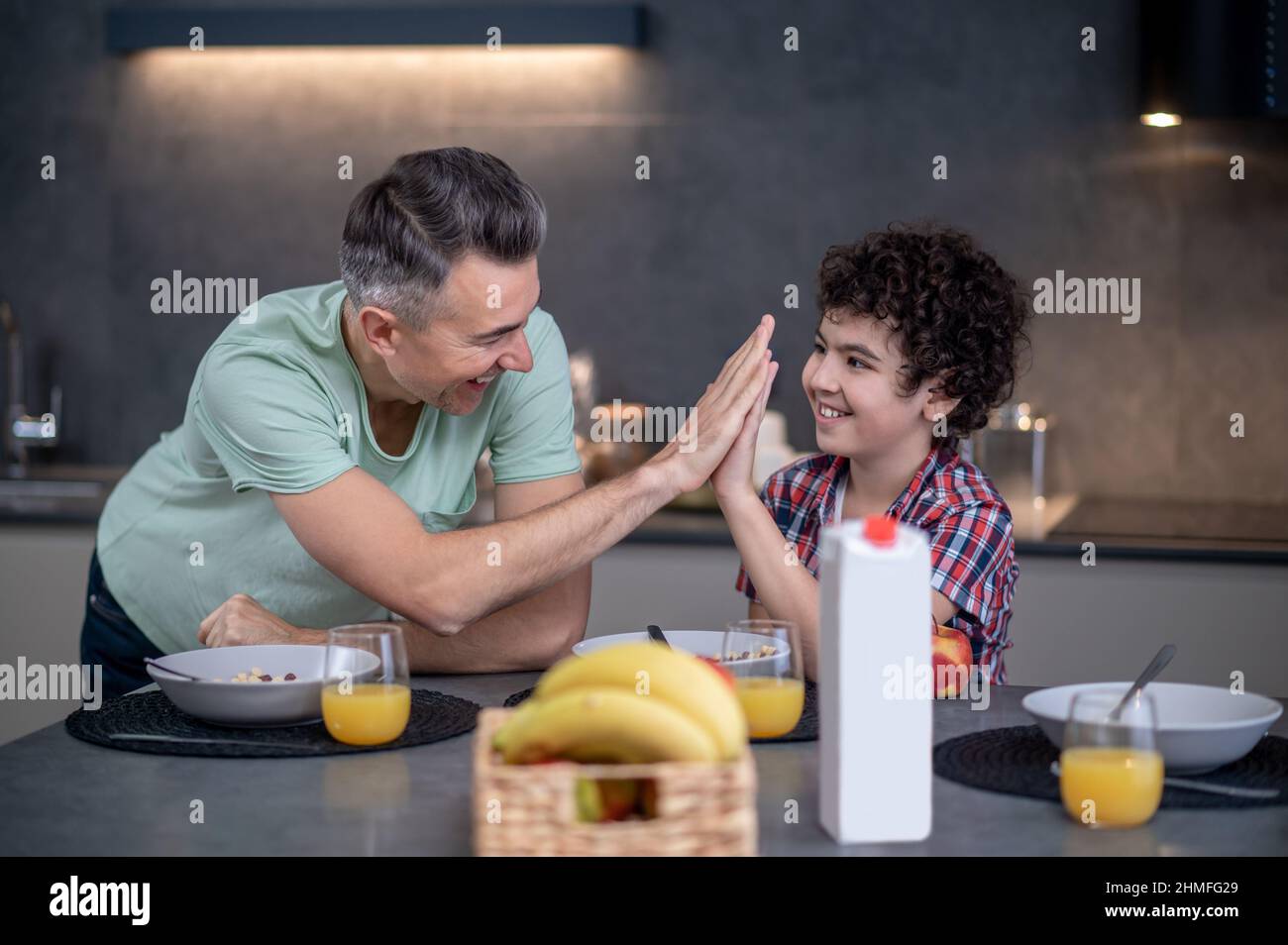 Man and boy touching palms as sign of understanding Stock Photo