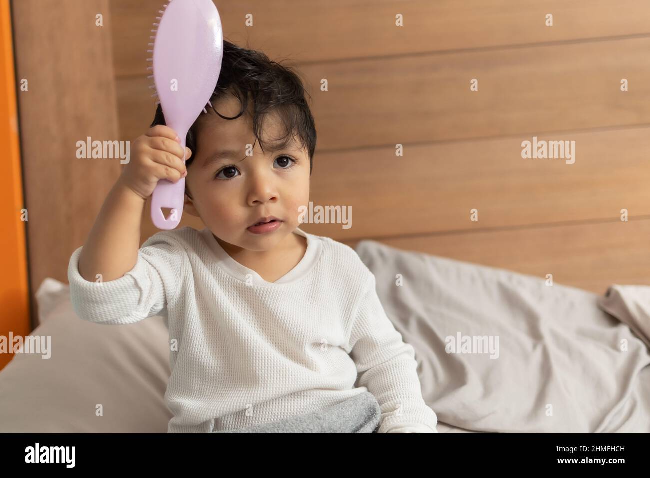 Adorable Hispanic 2 Year Old Baby Combing His Hair After Shower Stock