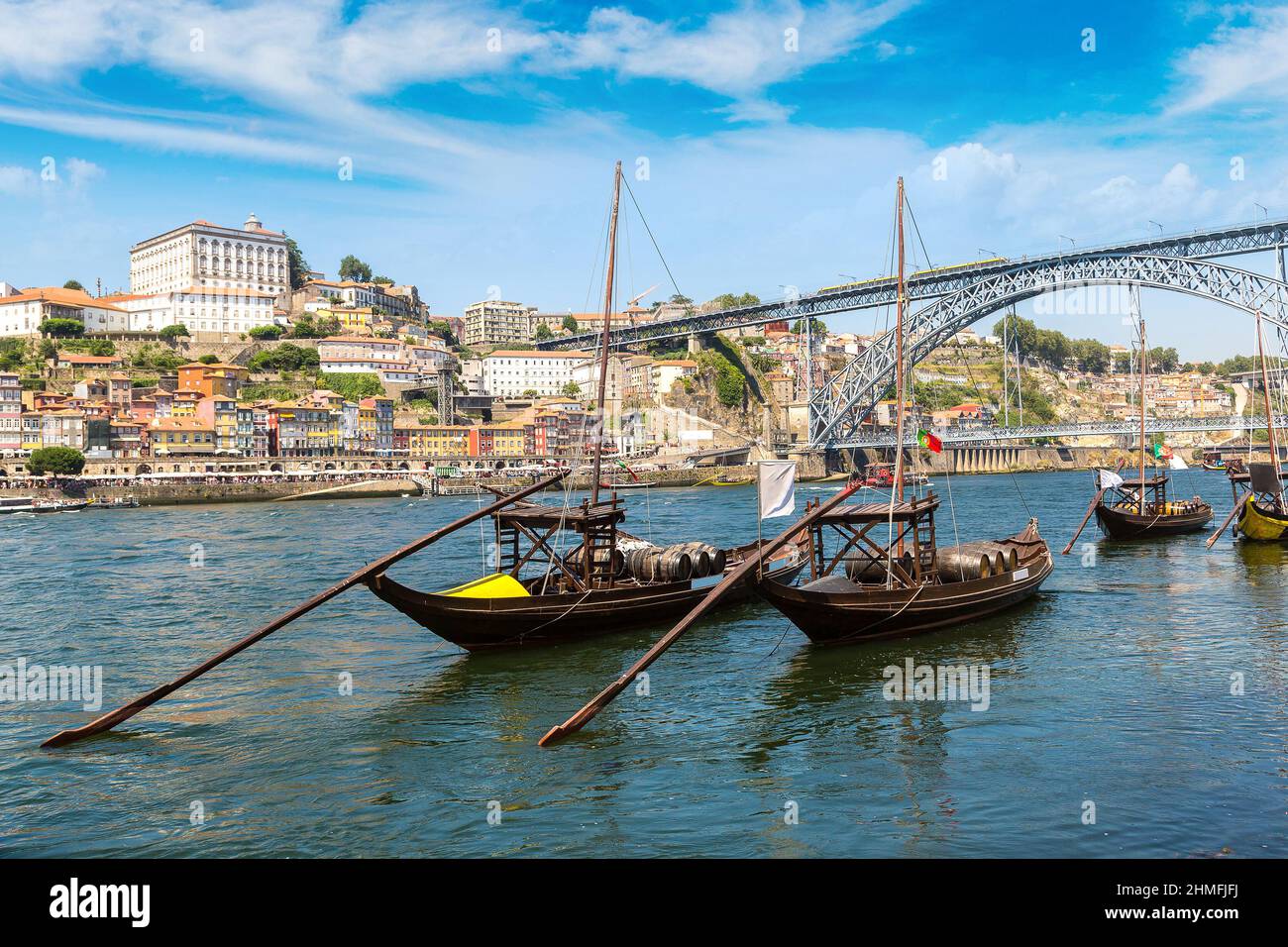 Traditional boats with wine barrels and Douro River in Porto in a beautiful summer day, Portugal Stock Photo