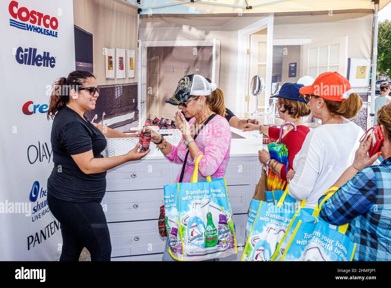 Miami Florida,Little Havana,Calle Ocho,annual street festival,Hispanic woman women offering,receiving,free product sample Costco Wholesale promotion Stock Photo