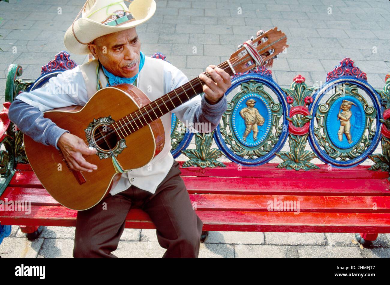 San Antonio Texas,Market Square,El Mercado troubadour guitar player Hispanic man ornate bench,La Margarita Mexican Restaurant & Oyster Bar Stock Photo
