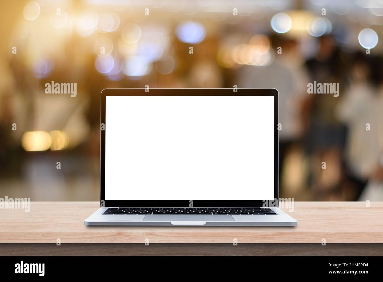 Modern Laptop computer with blank screen on wood table over blur bokeh ...