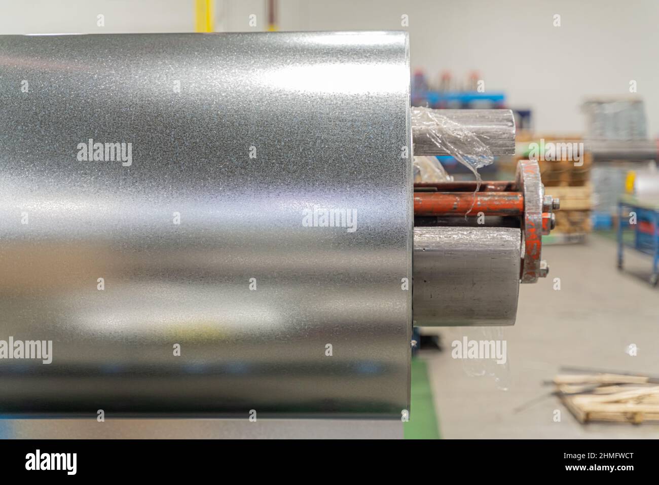 roll of silver metal steel coil in a metal roofing factory Stock Photo