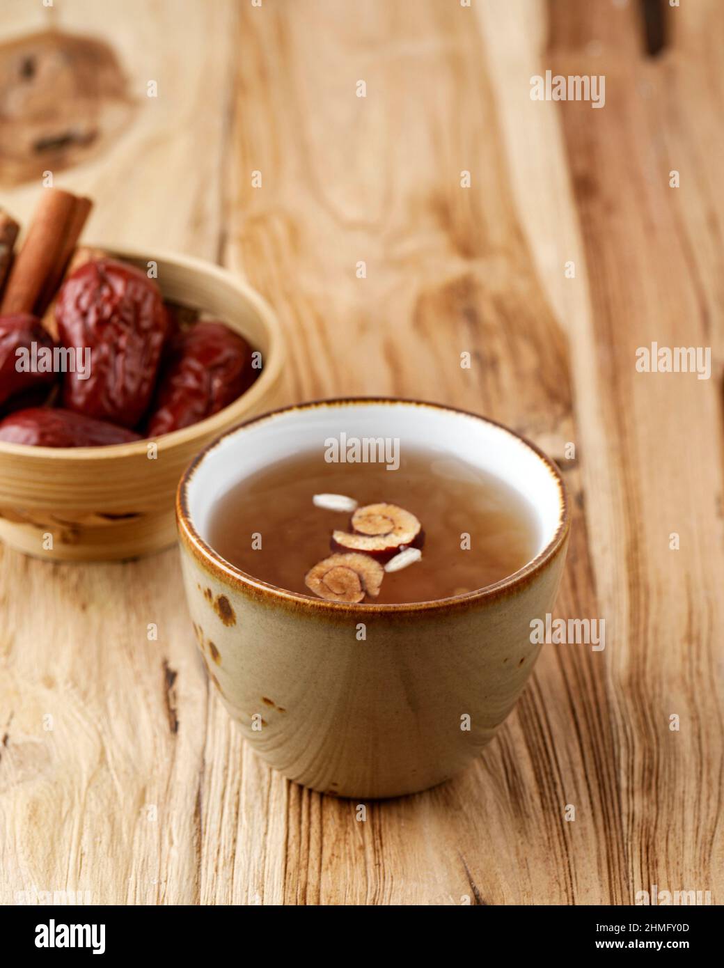 Sujeonggwa, Korean Traditional Cinnamon Punch. Dark Reddish Brown in Color, it is Made from Cinnamon Stick, Gotgam, and Ginger and is Garnished with P Stock Photo