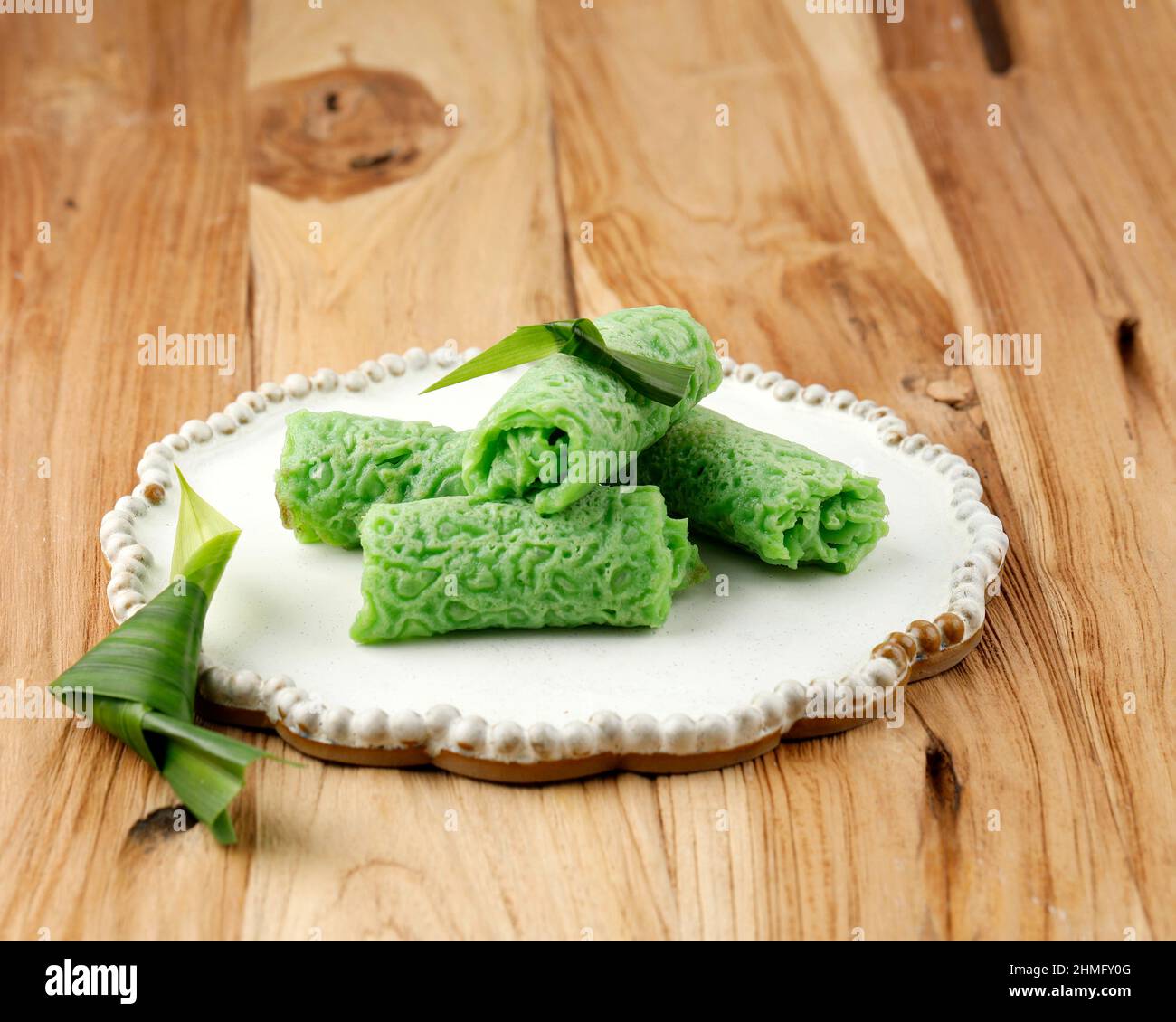 Dadar Gulung or Sweet Coconut Pancake, Indonesian Snack Dessert made from Flour with Sweetened Grated Coconut. Green Color from Pandan and Suji Leaves Stock Photo