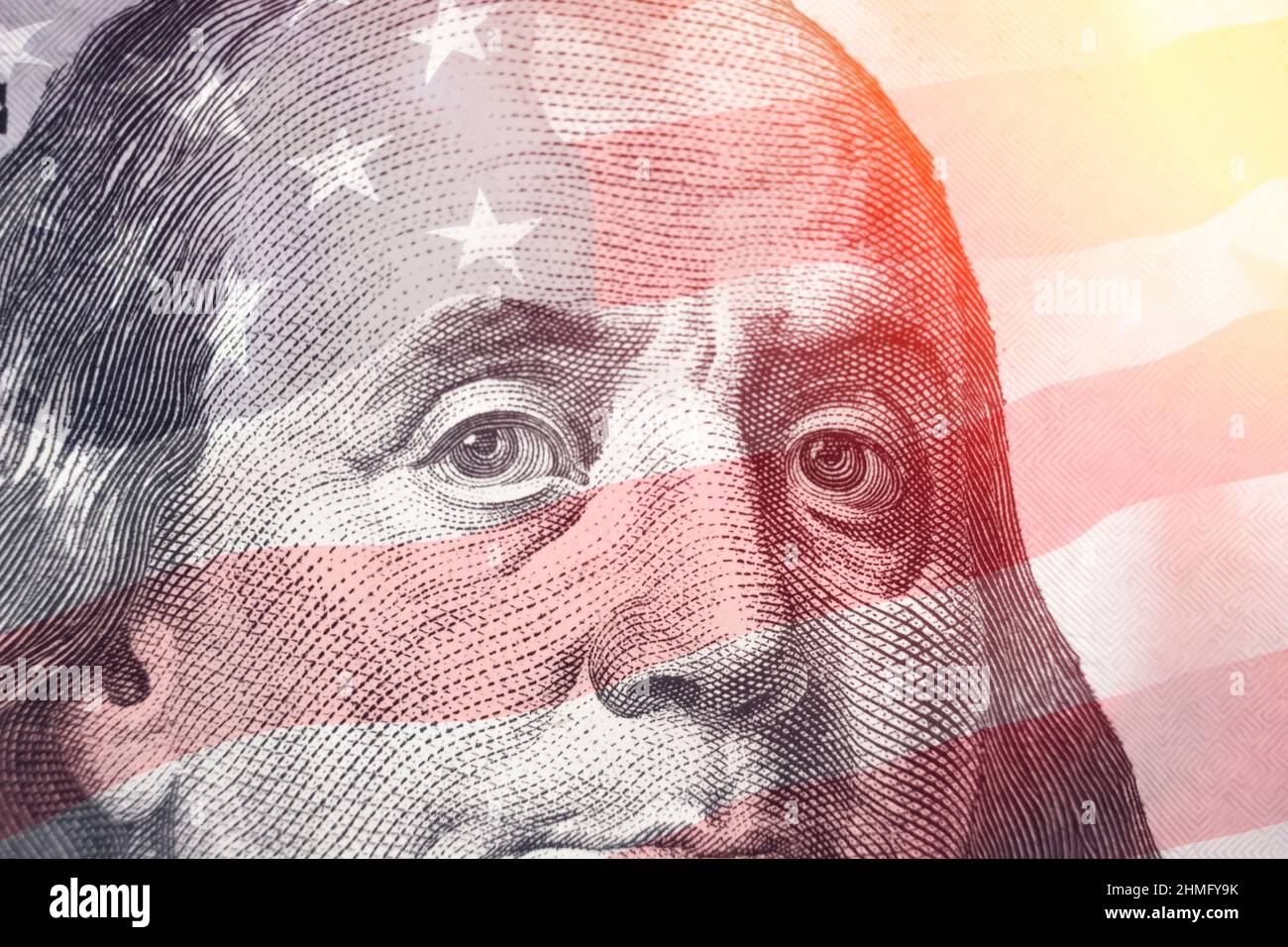 Portrait of US president Benjamin Franklin on 100 dollars banknote with american flag background. Close up of American currency. Macro shot Stock Photo