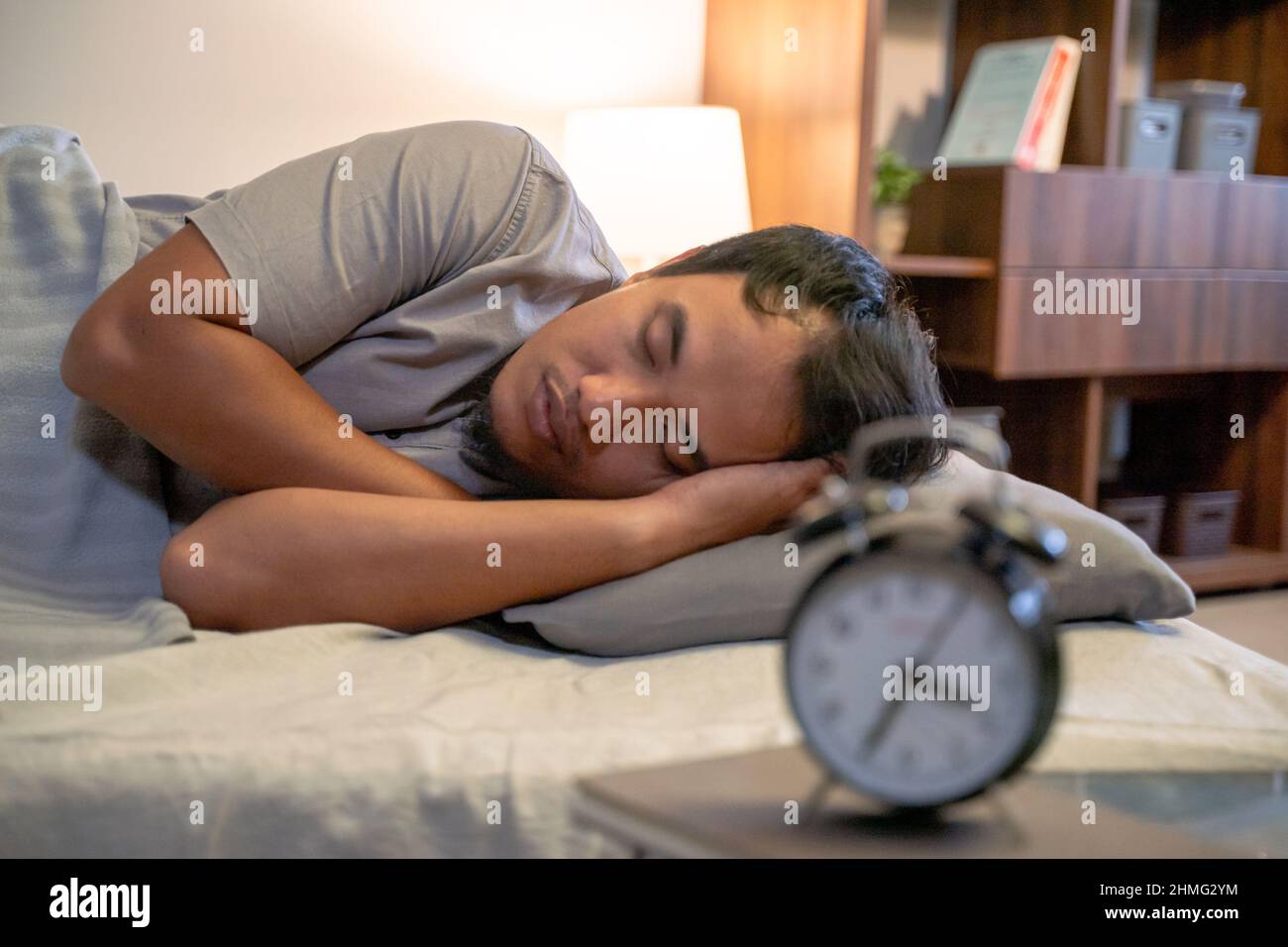 Young Asian man sleeping in bed Stock Photo