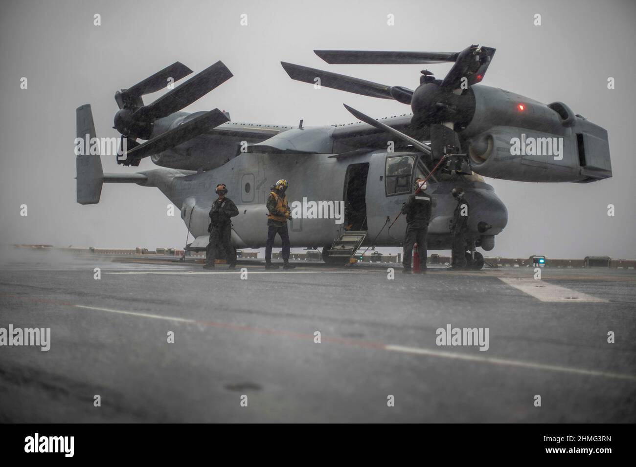 PHILIPPINE SEA (Jan. 25, 2022) U.S. Marines assigned to Marine Medium Tiltrotor Squadron (VMM) 165 (Reinforced), 11th Marine Expeditionary Unit (MEU), conduct routine maintenance on an MV-22B Osprey attached to VMM-165 (Rein.), 11th MEU, aboard amphibious assault ship USS Essex (LHD 2), Jan. 25, 2022. The 11th MEU and Essex Amphibious Ready Group are operating in the U.S. 7th Fleet area of operations to enhance interoperability with alliances and partners and serve as a ready response force to ensure maritime security and a free and open Indo-Pacific region.  (U.S. Marine Corps photo by Sgt. I Stock Photo