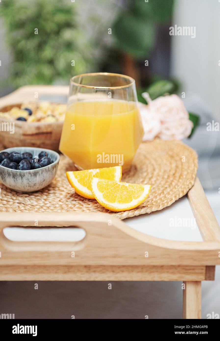 Healthy breakfast. Orange juice, fruits and bowl with granola on a tray
