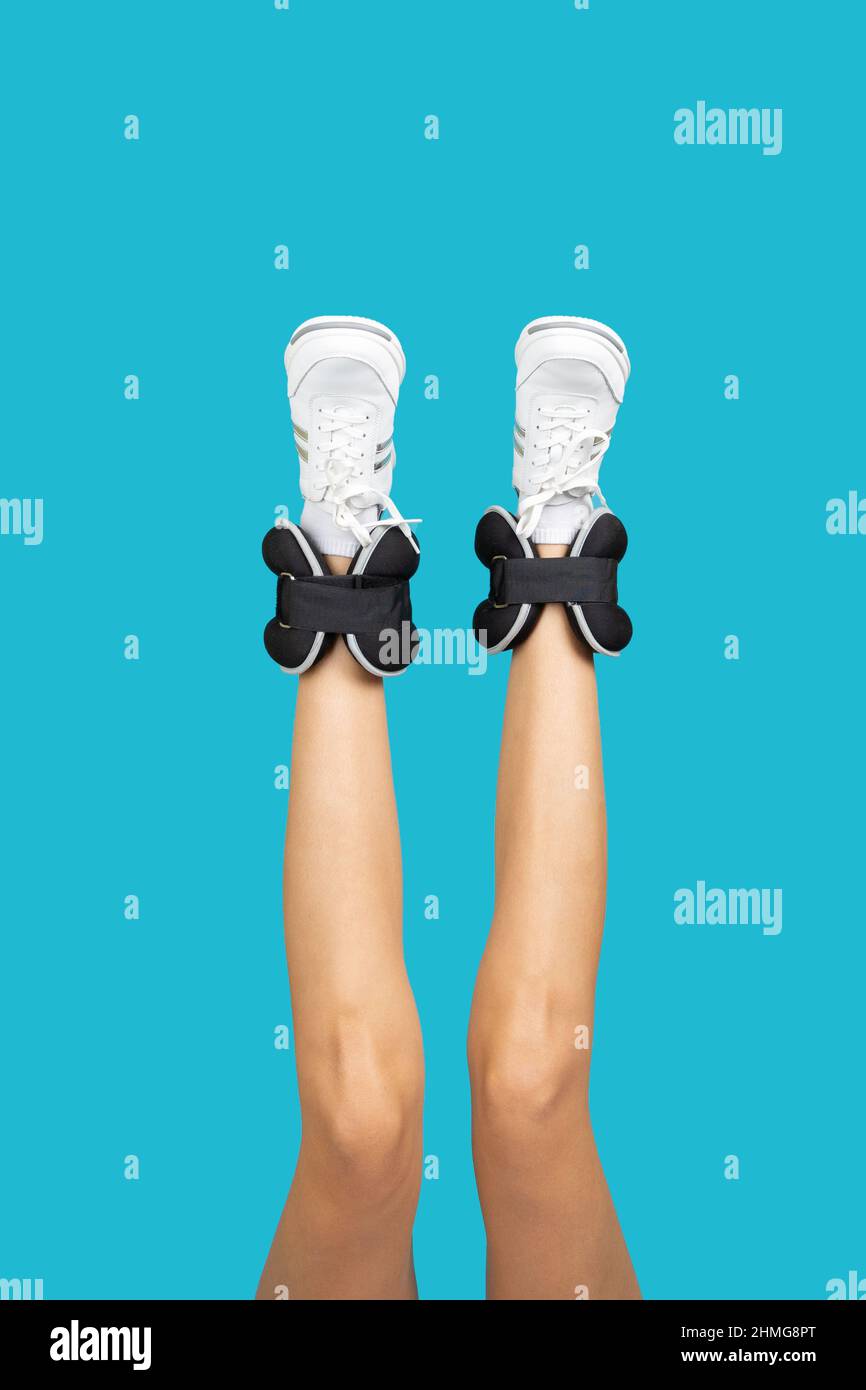 Woman long legs upside down wearing white sneakers and black ankle