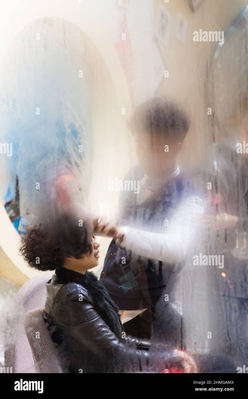 Through the steamy window of a barber shop. Jiashan, China Stock Photo