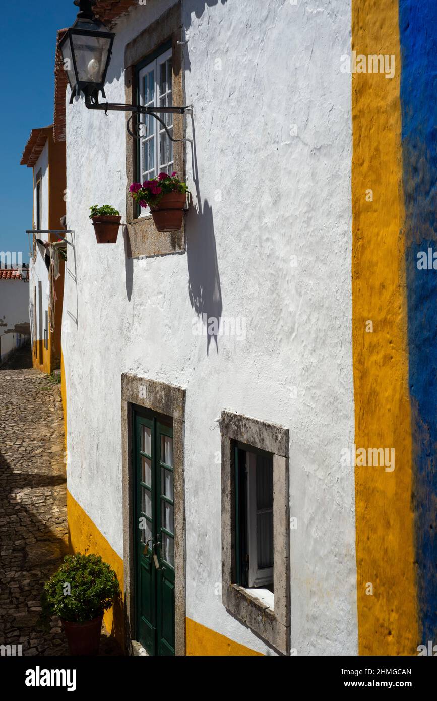 Elegant street lantern on traditional property on quiet street in Óbidos, Centro, Portugal Stock Photo