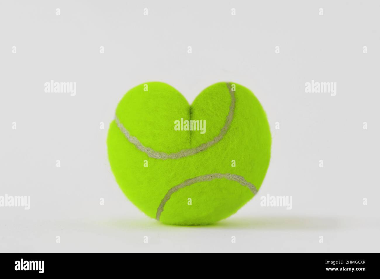 Heart shaped tennis ball - Concept of love and game Stock Photo