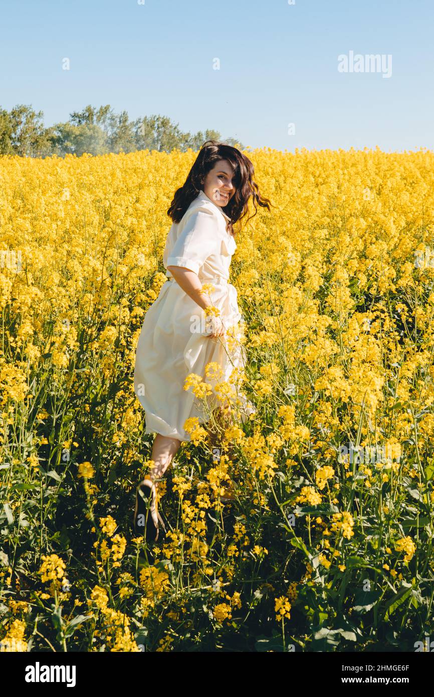 beautiful woman standing in rapeseed field summertime Stock Photo - Alamy