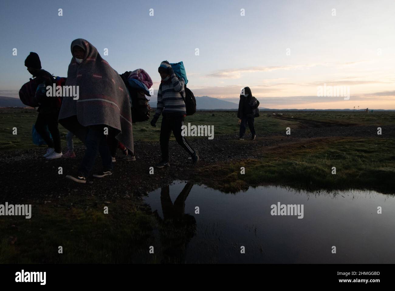 Daily migrants seen walking on adverse roads to reach Chile, between the Bolivian border, in Colchane.Venezuelan migrants arrive in Chile in search of job opportunities due to the economic crisis in Venezuela. Upon arrival in Chile, most seek to go to the Chilean capital, Santiago, and there they work in whatever it takes to send money to their families  in Venezuela. The population of Venezuelans in Chile reaches 500,000 people. Stock Photo