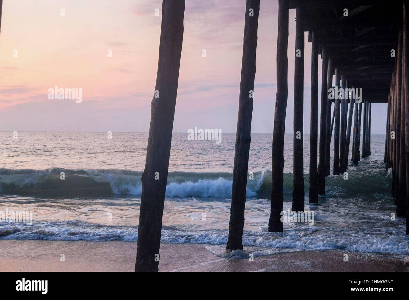 You can fish in the Atlantic Can from the pier over the beach in Ocean City, Maryland Stock
