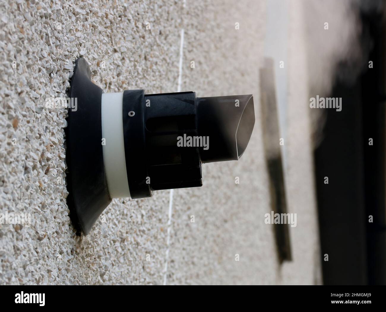 Steaming central heating boiler vent on an external house wall Stock