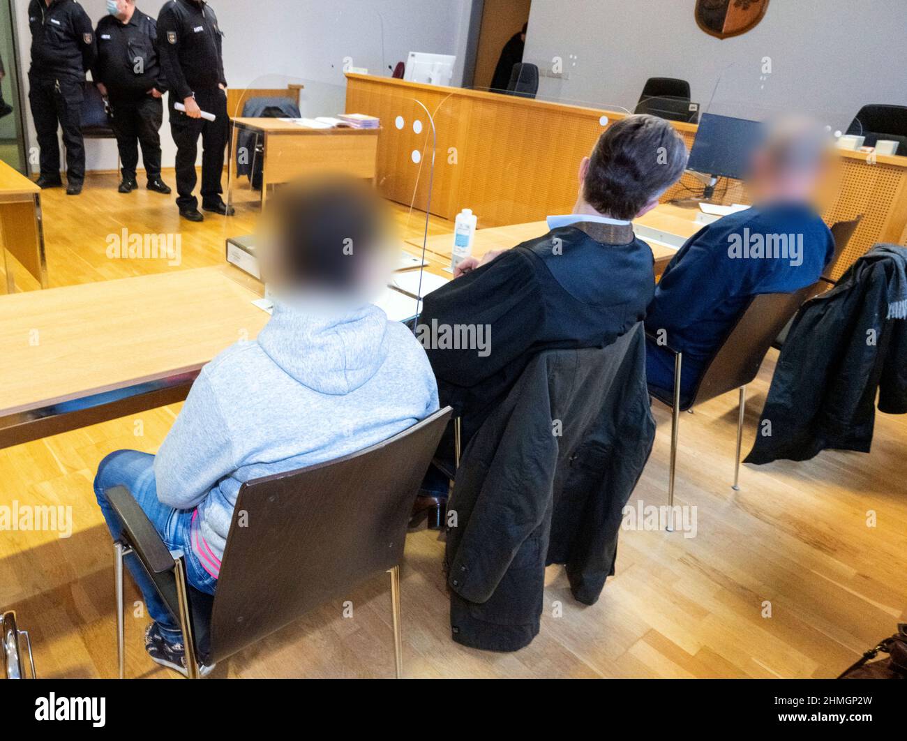 Pasewalk, Germany. 10th Feb, 2022. Two defendants sit with a lawyer (M) in  the district court at the start of the trial. The Pasewalk District Court  (Vorpommern-Greifswald) is dealing for the first