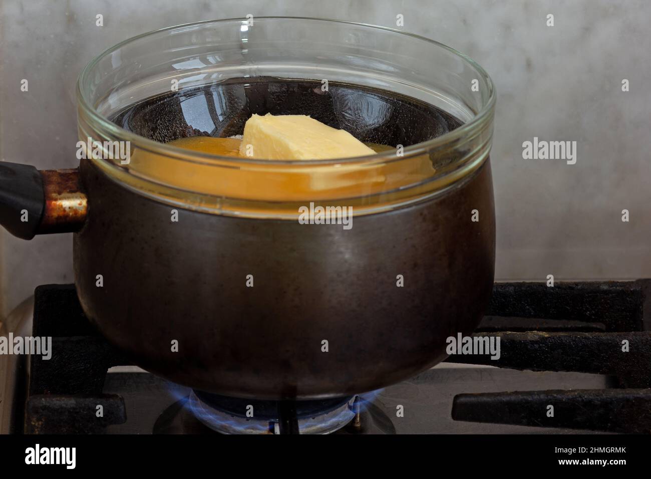 Bain-marie with sugar, butter and honey in glass bowl on saucepan as  ingredients of cake medovik on stovetop Stock Photo - Alamy