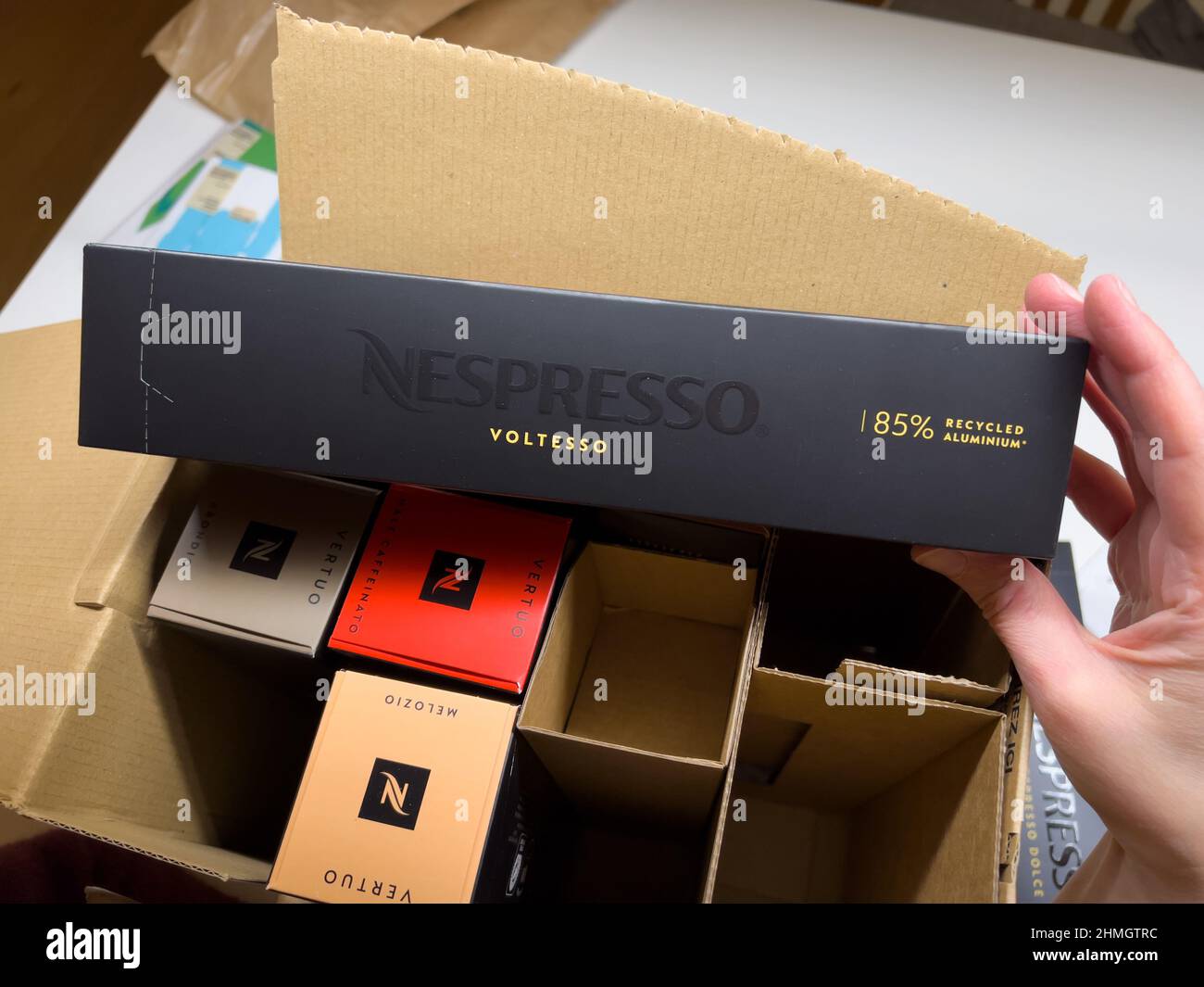 Munich, Germany - Dec 9, 2021: POV male hand unboxing unpacking package  with Nespresso multiple coffee capsules inside, Vertuo, Voltesso caps made  from 85 percent recycled aluminium Stock Photo - Alamy