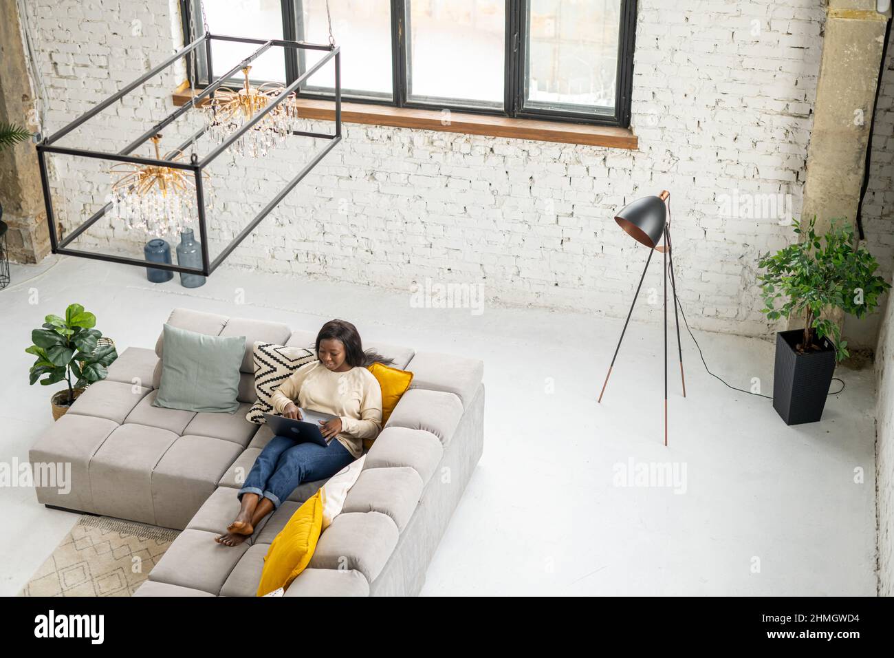 High angle view at african-american woman using laptop lying down on ...