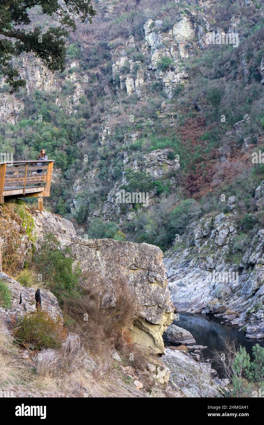 Young girl looking at the landscape on wooden walkways in the mountains Stock Photo