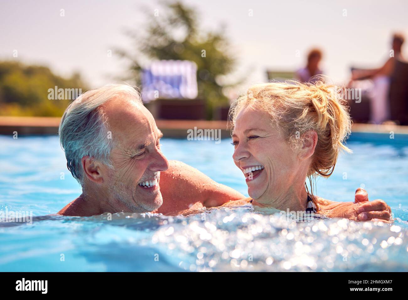 Retired Senior Couple Relaxing In Swimming Pool On Summer Vacation ...