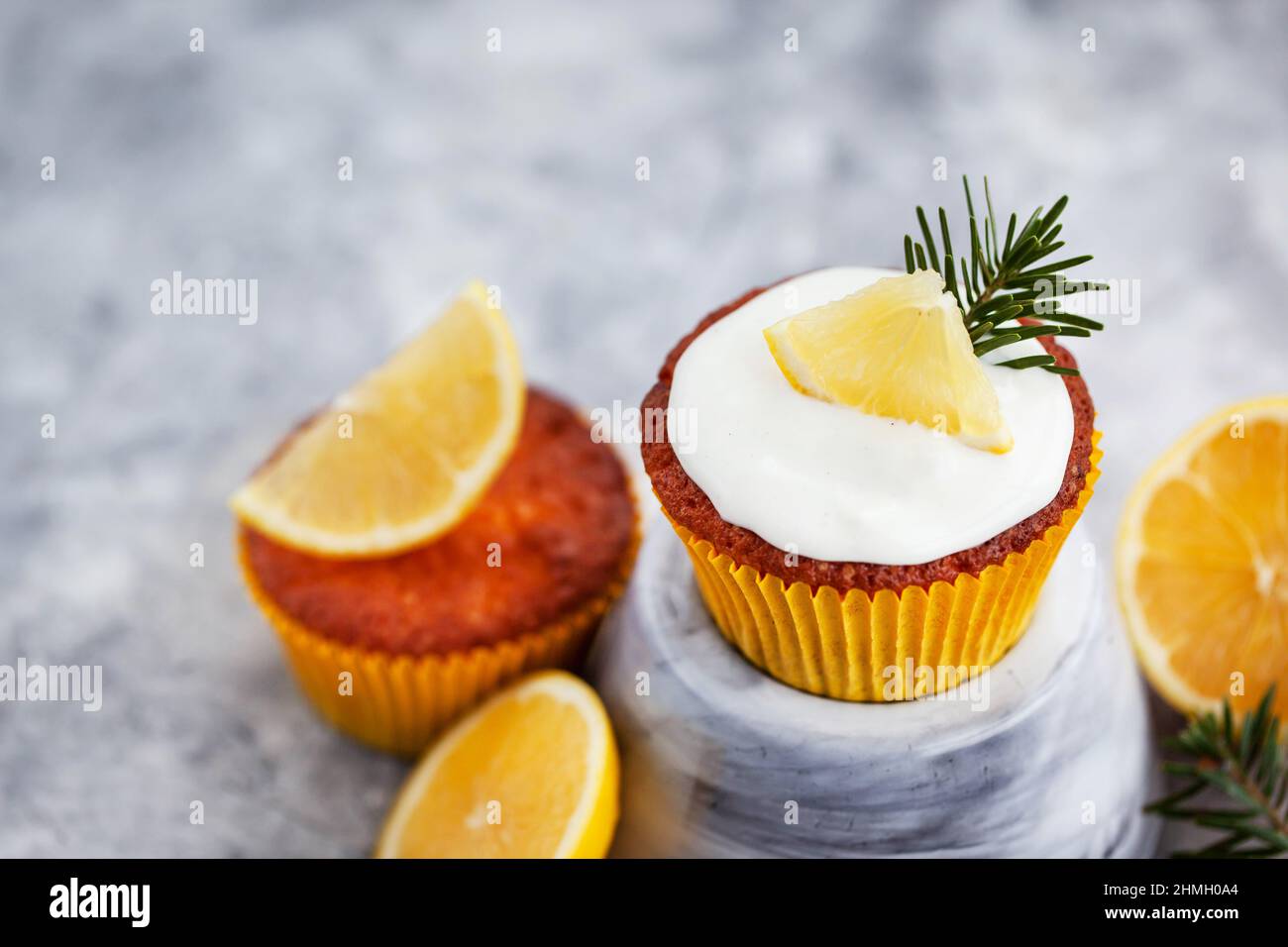 Homemade delicious lemon cupcakes, decorated with cream cheese and fresh citrus fruits Stock Photo