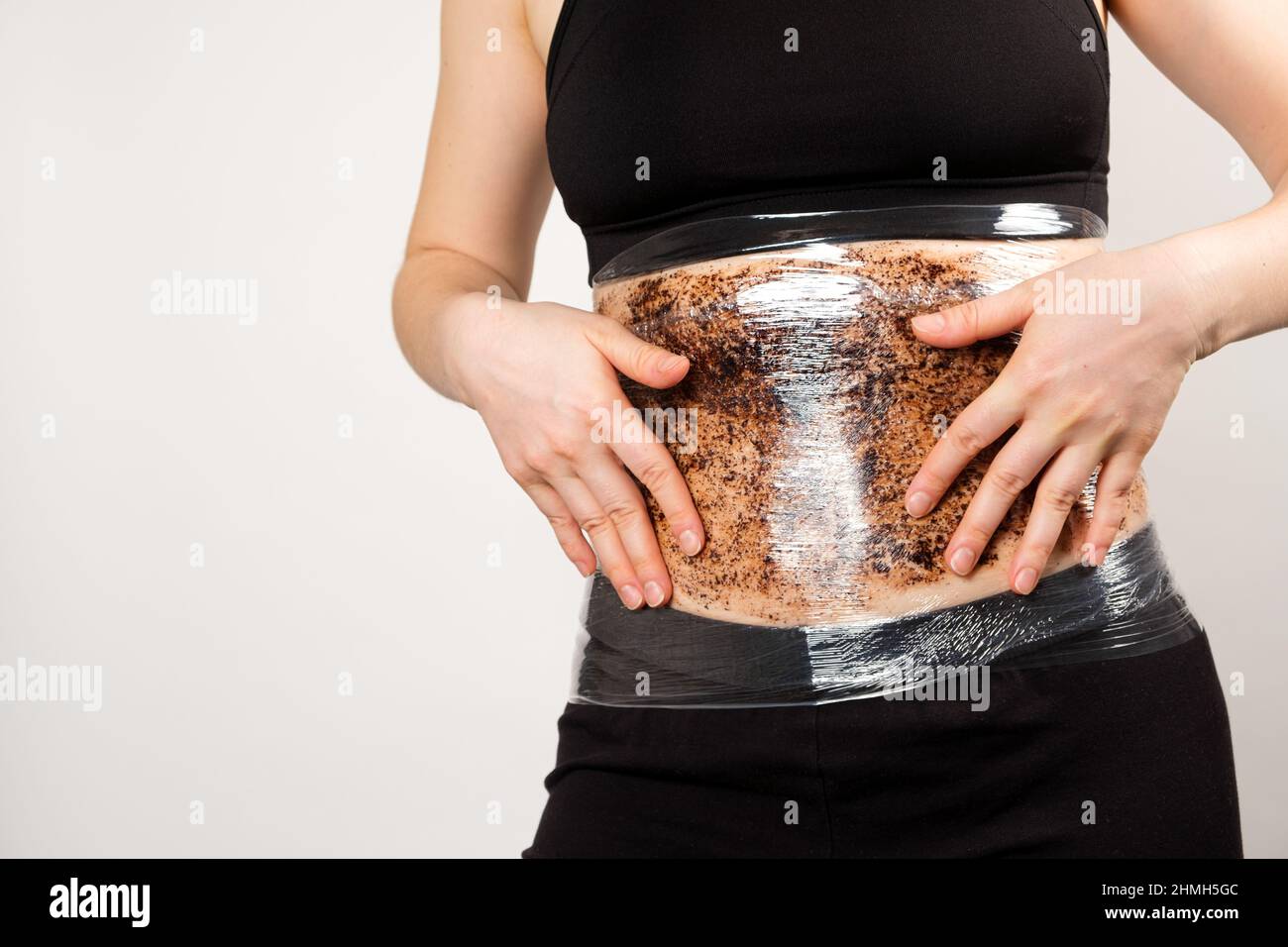 A woman makes a belly wrap with a coffee anti cellulite body scrub. The concept of weight loss and skin care Stock Photo Alamy