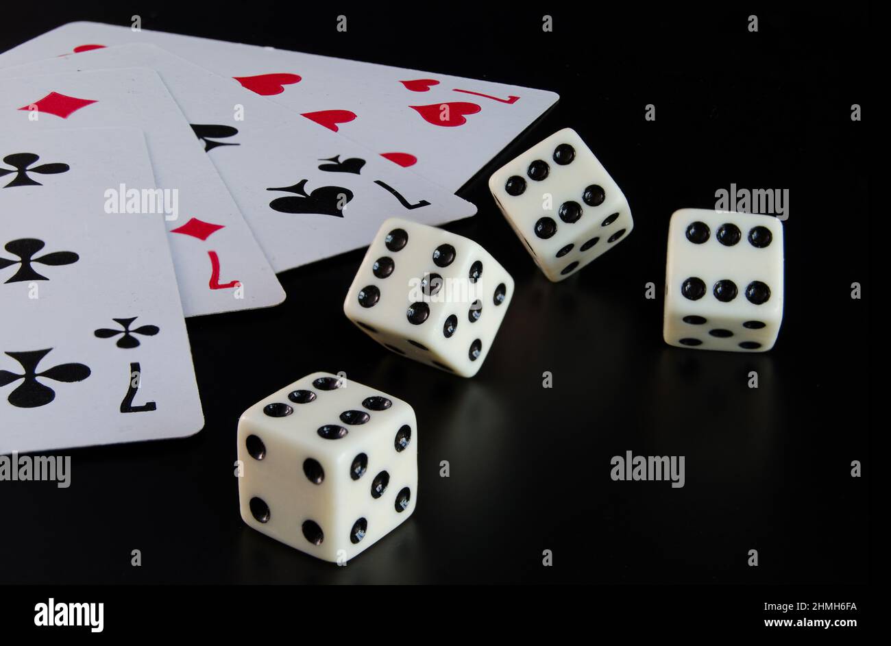 Dice, playing cards on a black background thrown on the table Stock Photo