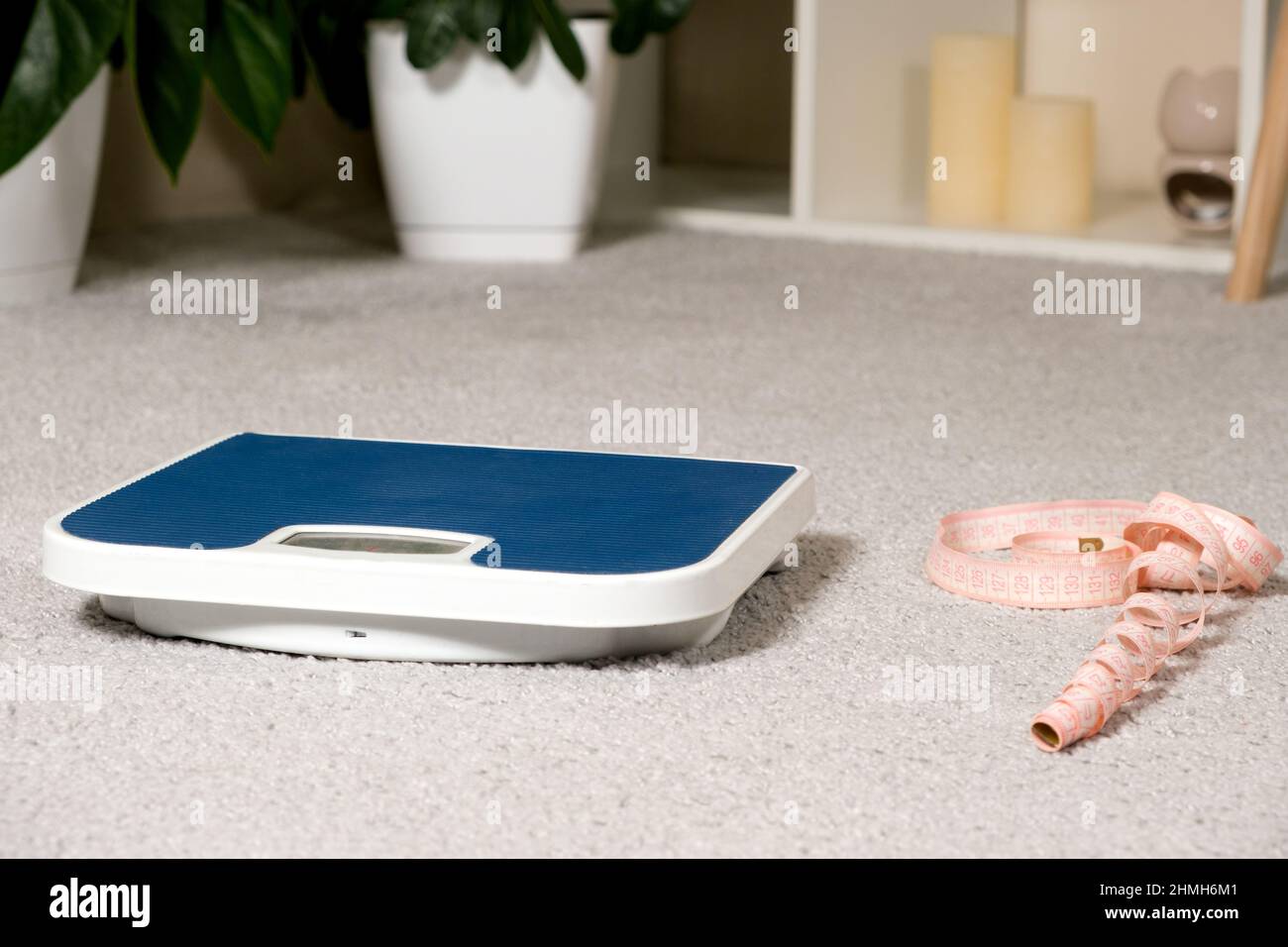 Floor blue scales and centimeter measuring tape on a gray carpet in the