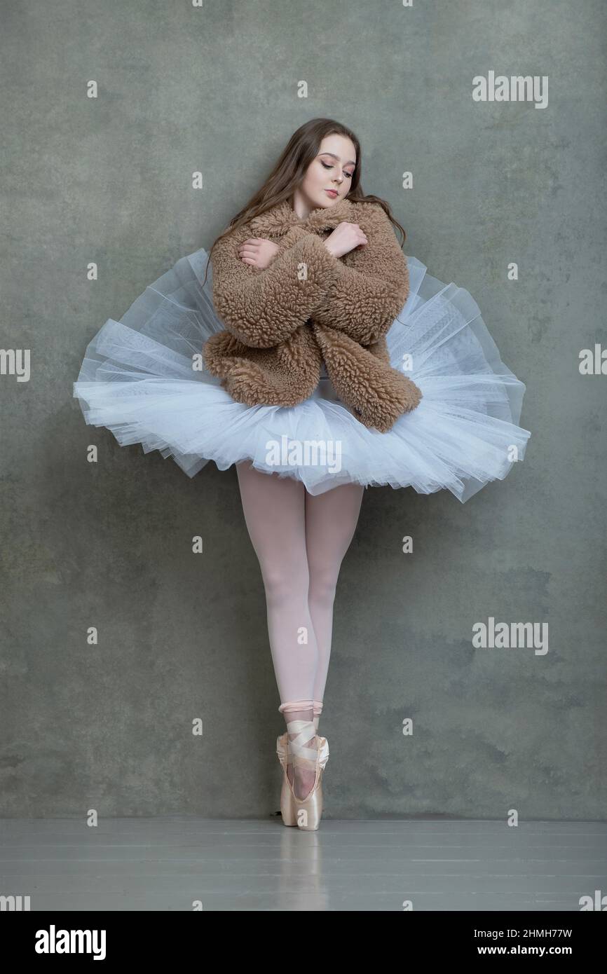 Ballerina in white tutu and pointe shoes with long brown hair flowing Stock Photo