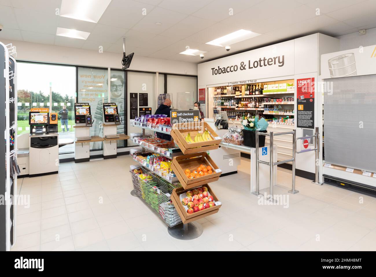 Inside a Sainsbury's Local store in the UK, showing the till area with tobacco and lottery products Stock Photo