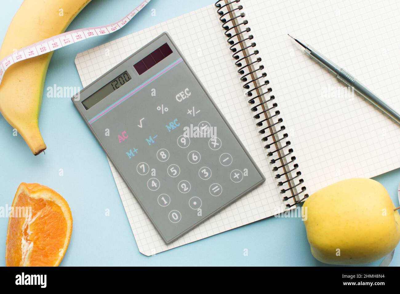 Empty paper notebook, calculator with numbers 1200, pen, measuring tape ...