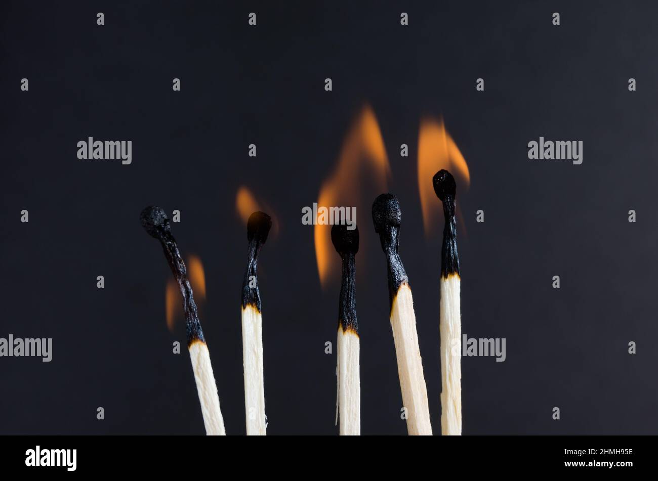 Burning matches with orange flames on a black background Stock Photo