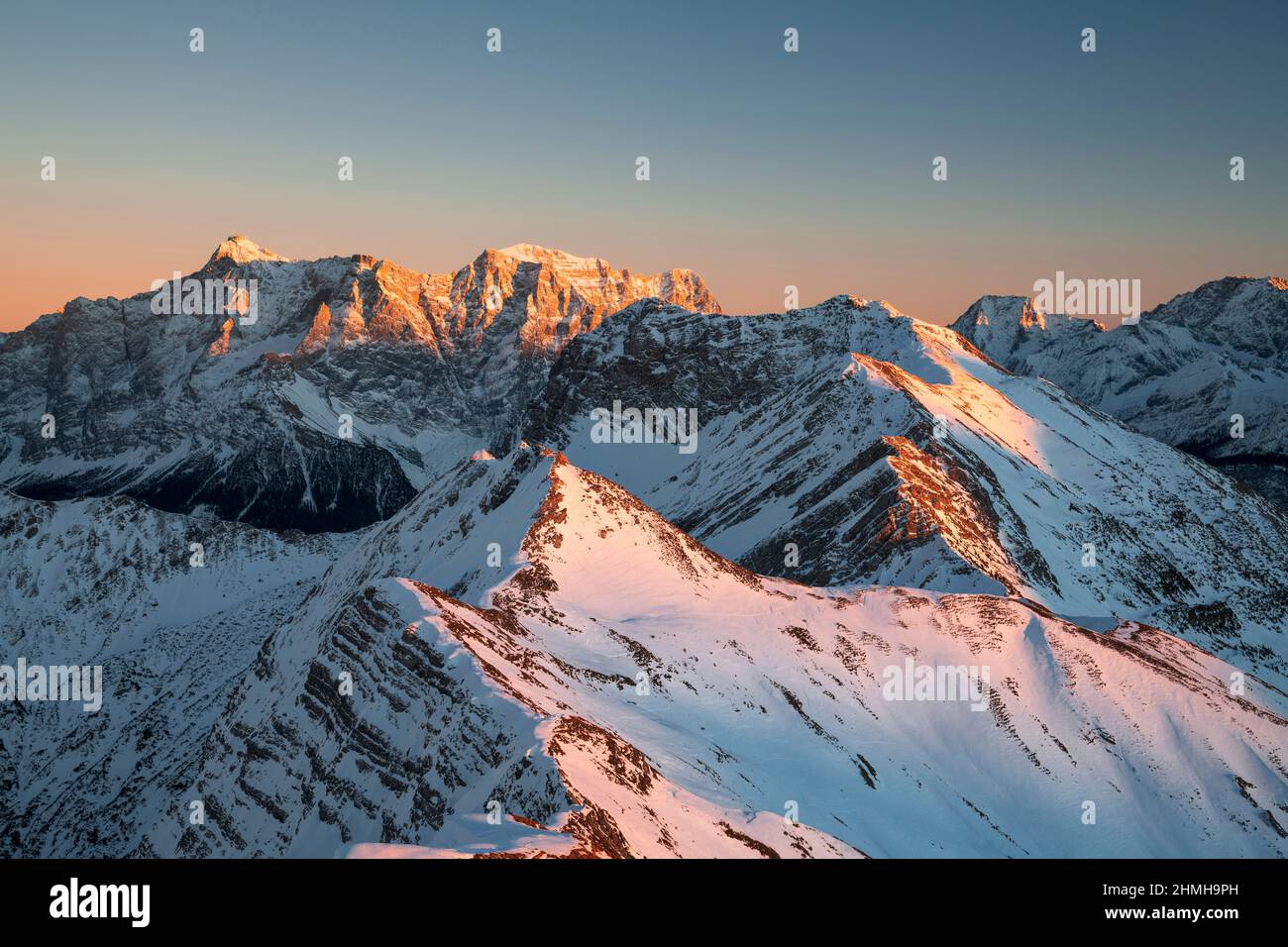 Beautiful sunset over alpine mountain landscape on a cold winter day. View from the Hochschrutte (Ammergau Alps) to the Zugspitze. Tyrol, Austria, Europe Stock Photo