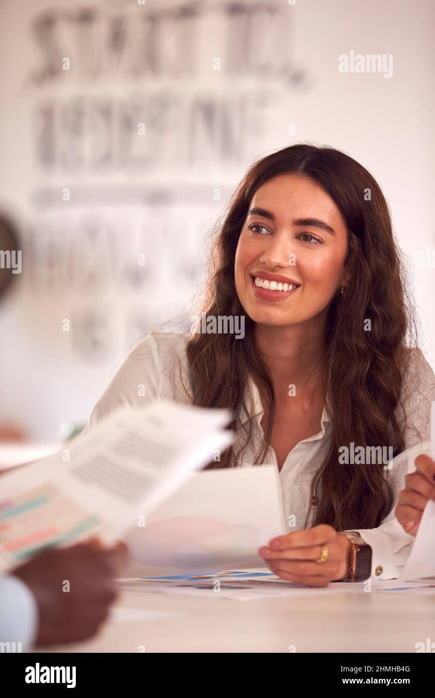 Group Of Business Colleagues Having Informal Meeting Around Table In Office Coffee Shop Stock Photo