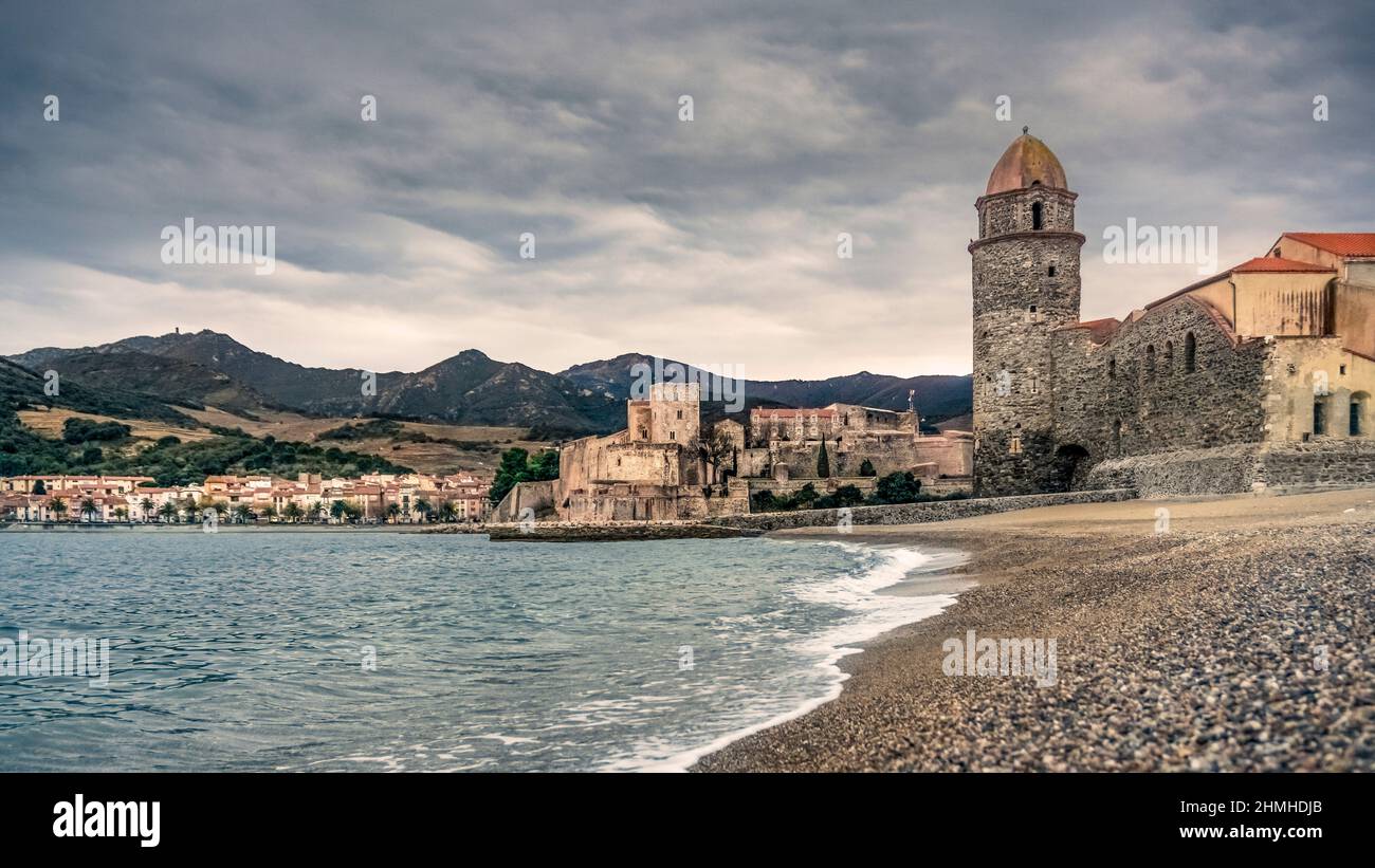 Ansa de la Baleta in Collioure. The Church of Notre Dames des Anges, on the right, was built at the end of the XVII century. The Château Royal de Collioure, on the left, like the church, is classified as a monument historique. First mentions date from the VII century. Stock Photo