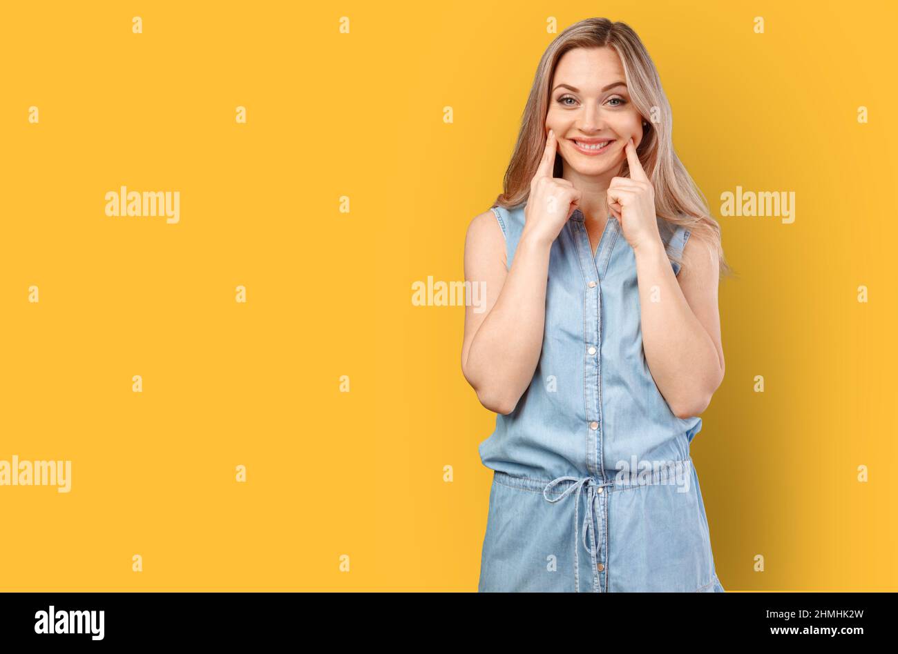 Beautiful young woman with fake smile isolated on color background. Stock Photo
