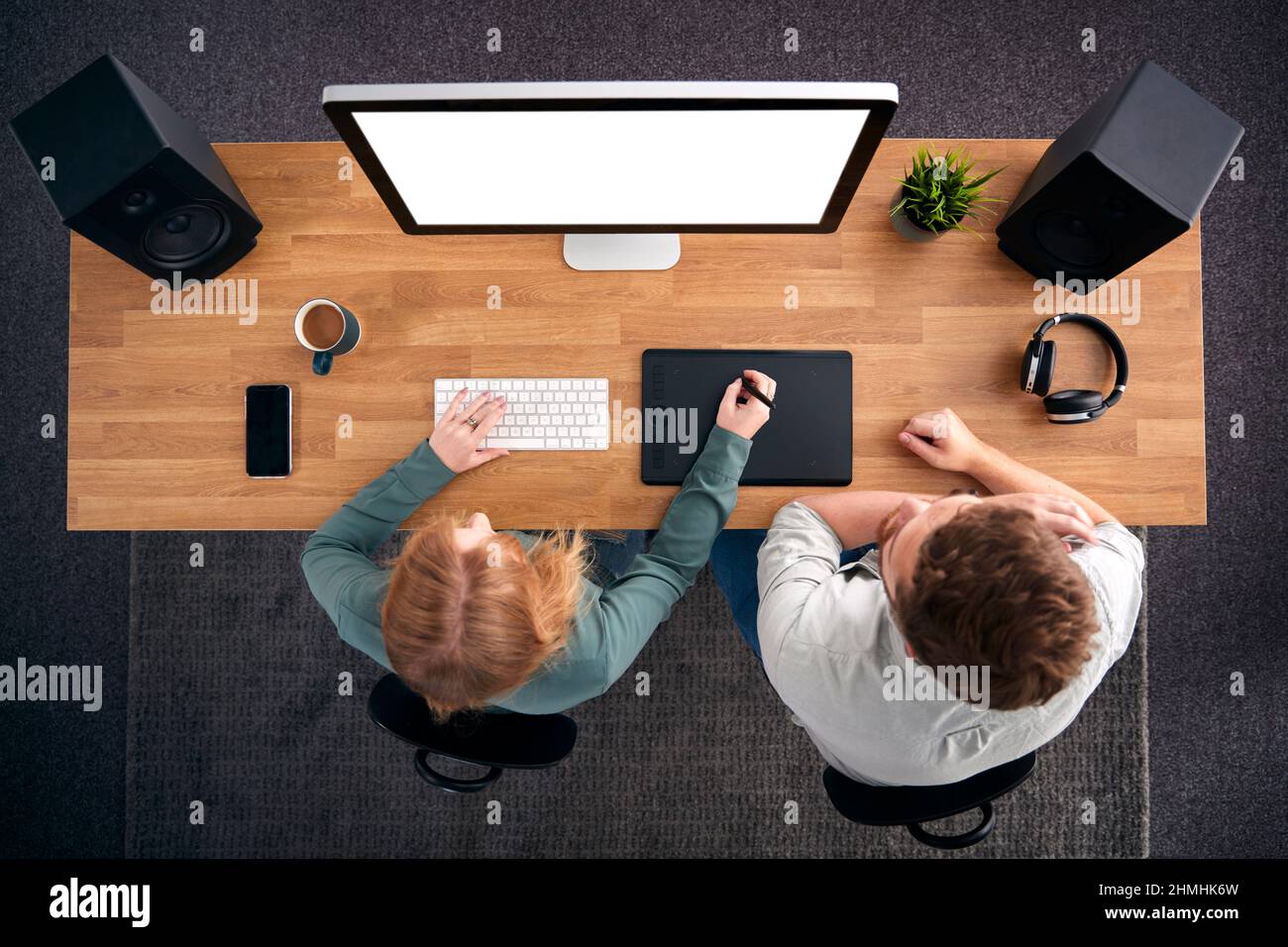 Overhead View Of Male And Female Graphic Designers Working At Computer In Creative Office Stock Photo