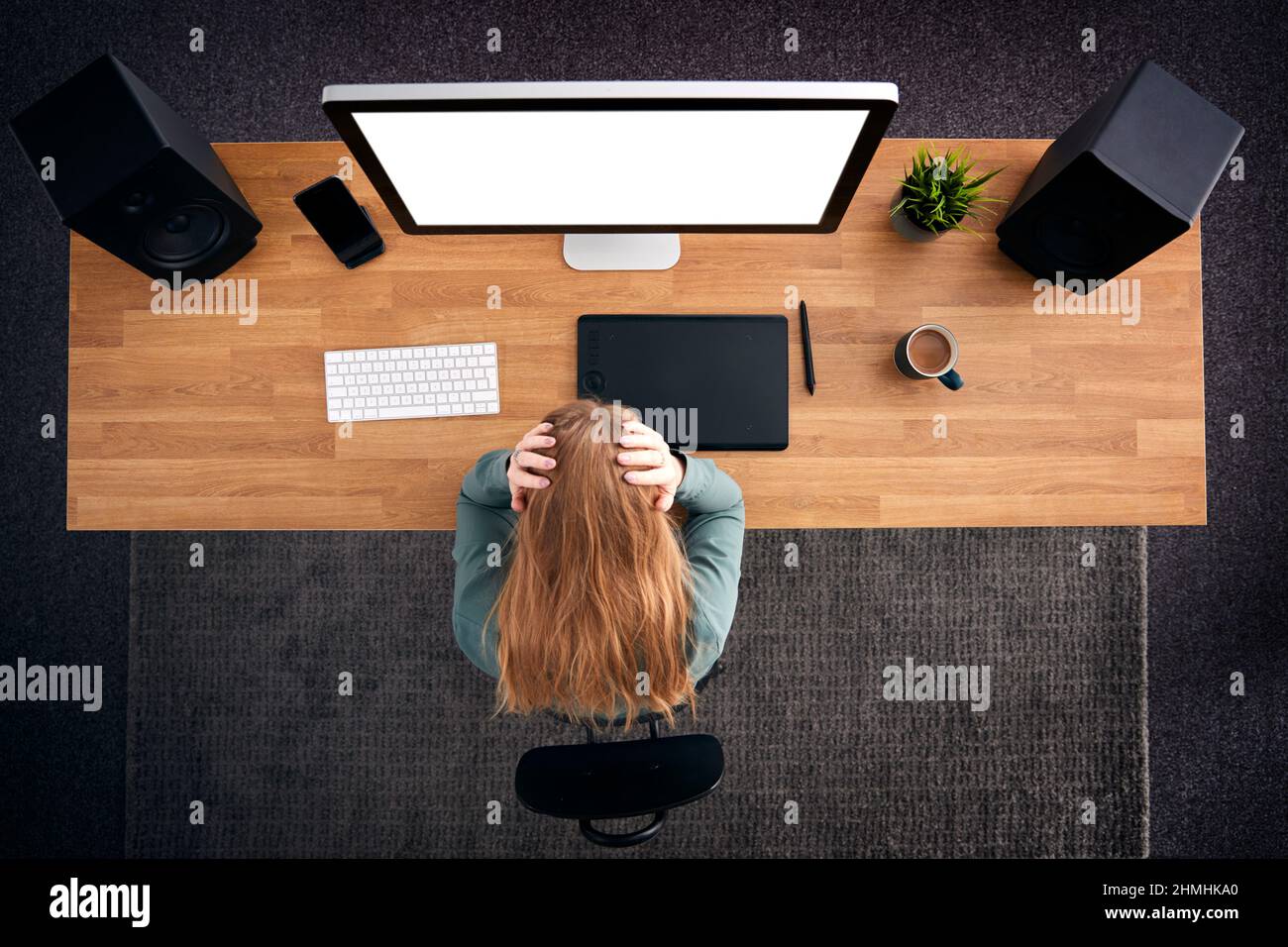 Overhead View Of Stressed Female Graphic Designer At Computer With Head