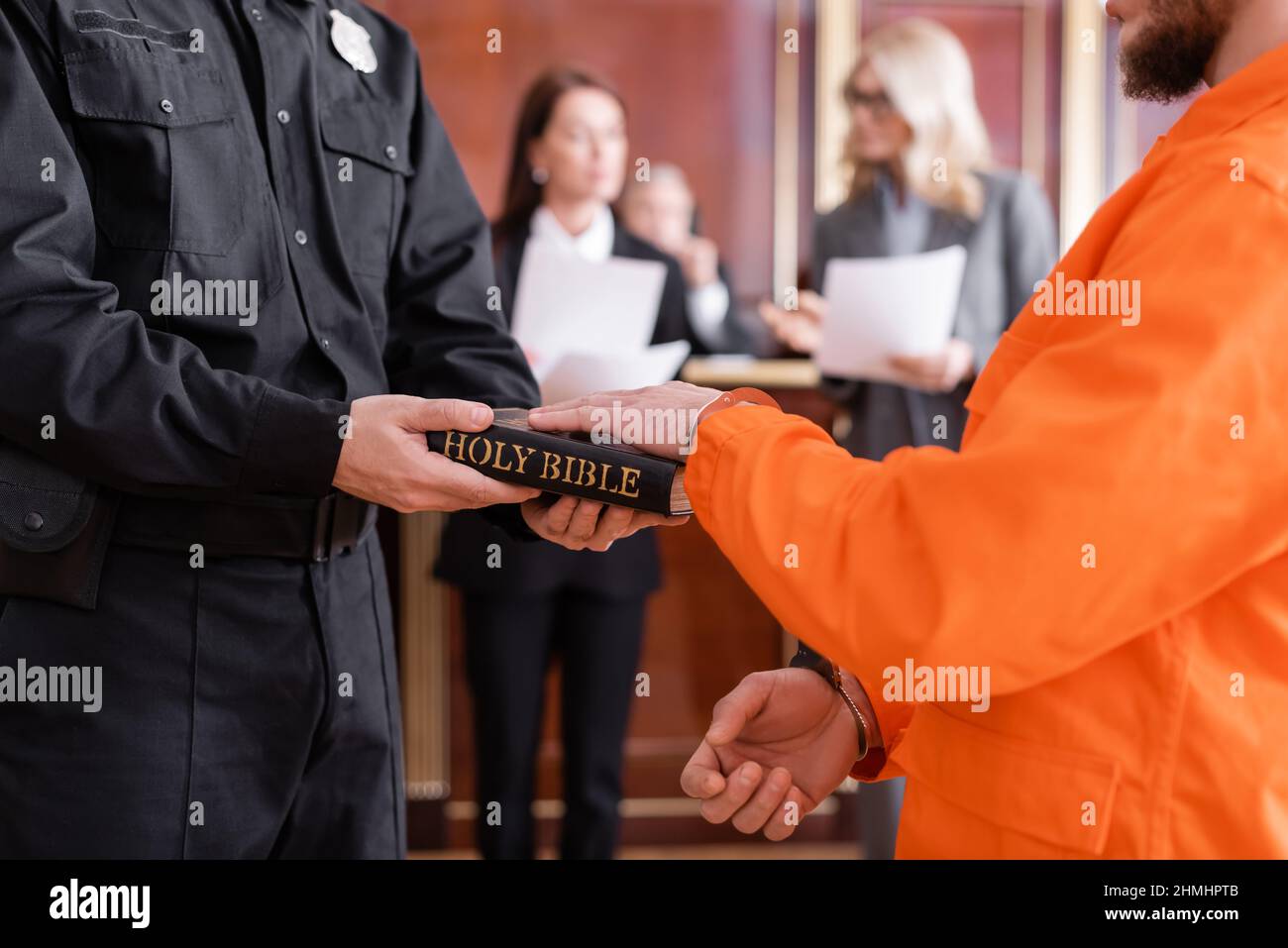 bailiff in uniform holding bible near accused man giving oath in court Stock Photo Alamy