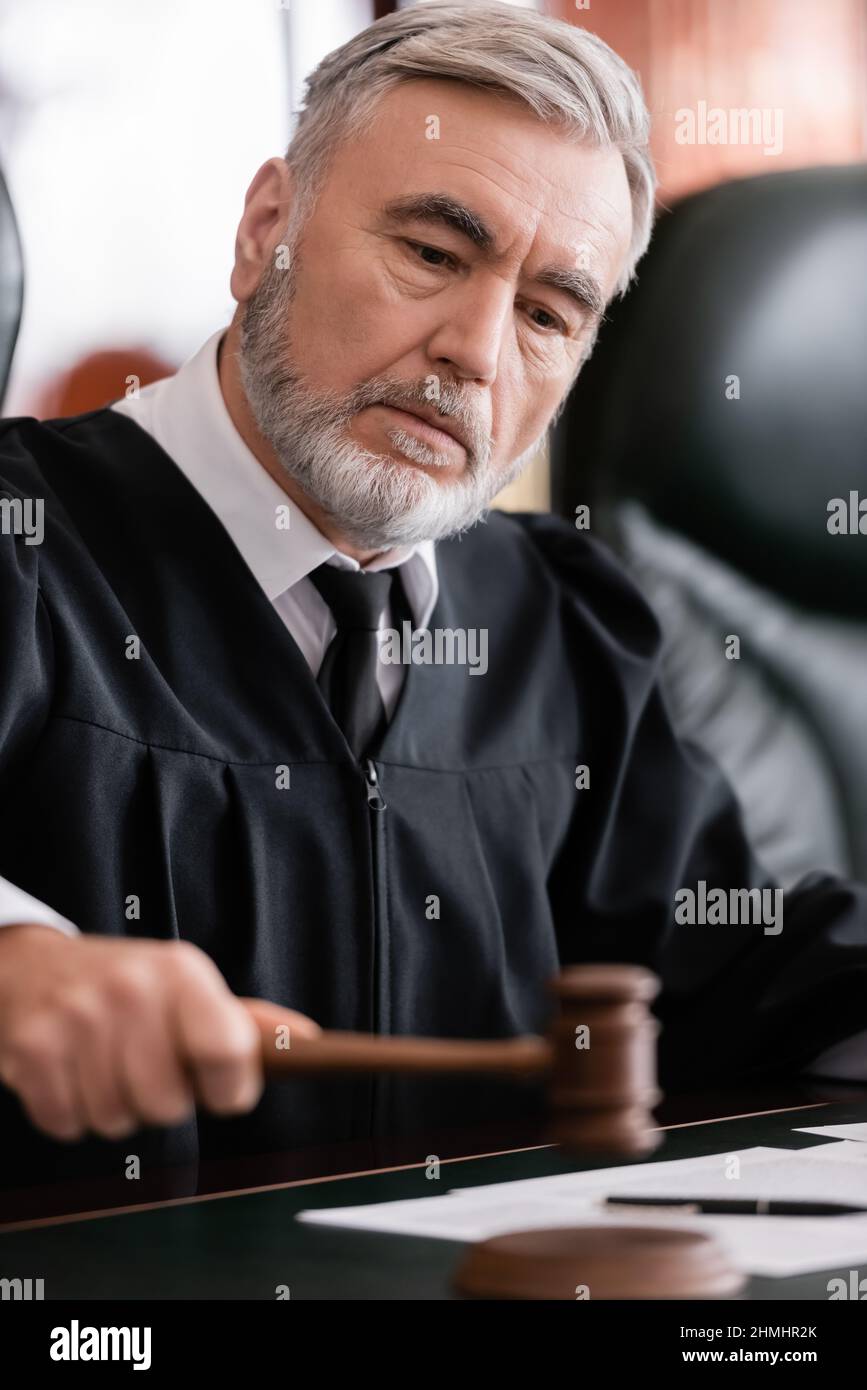 senior judge with blurred gavel sentencing in court Stock Photo